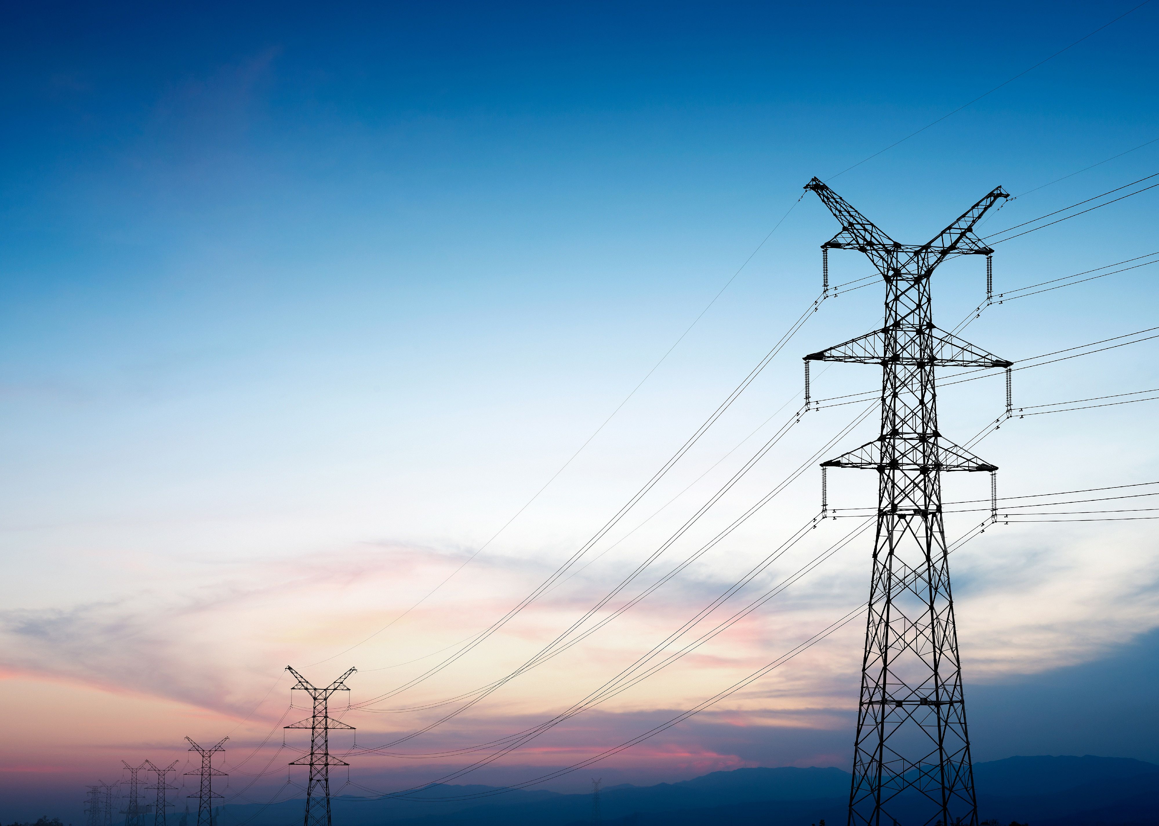 Pylon and transmission power line in sunset.