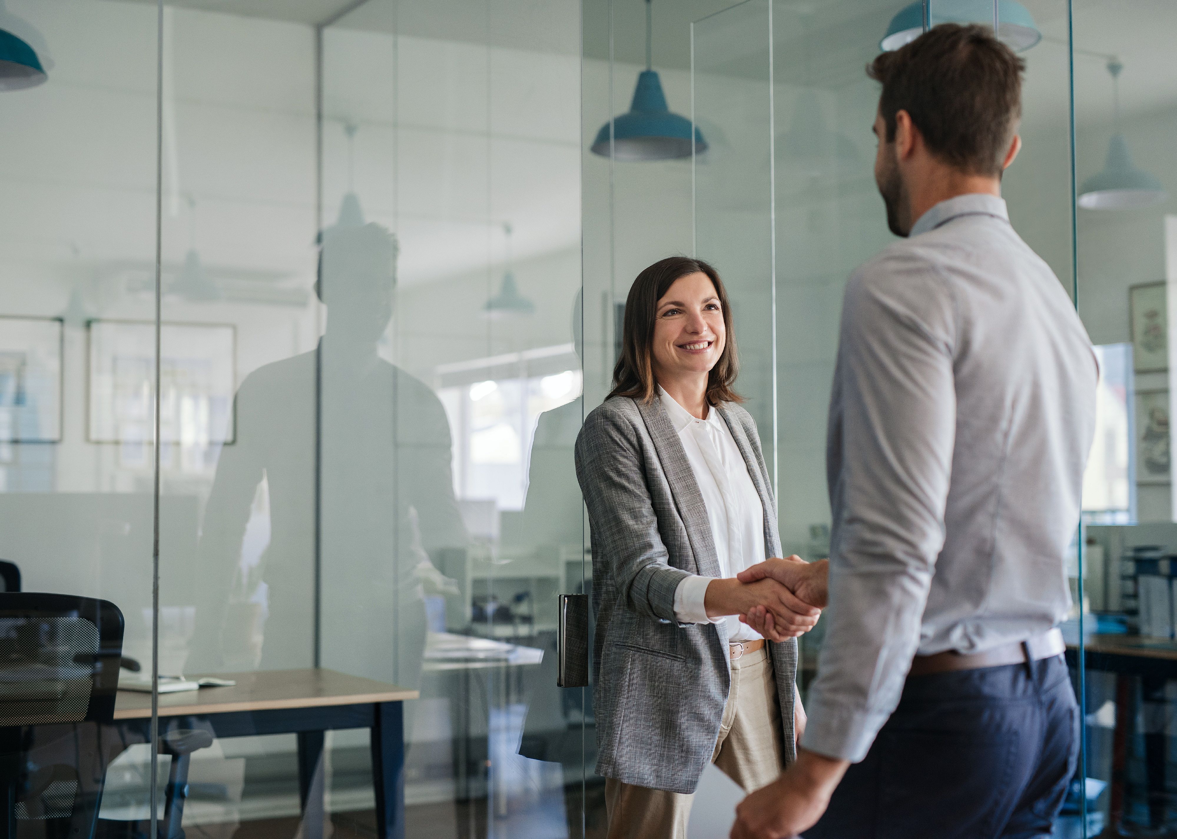 Manager outside of a office shaking hands with a man