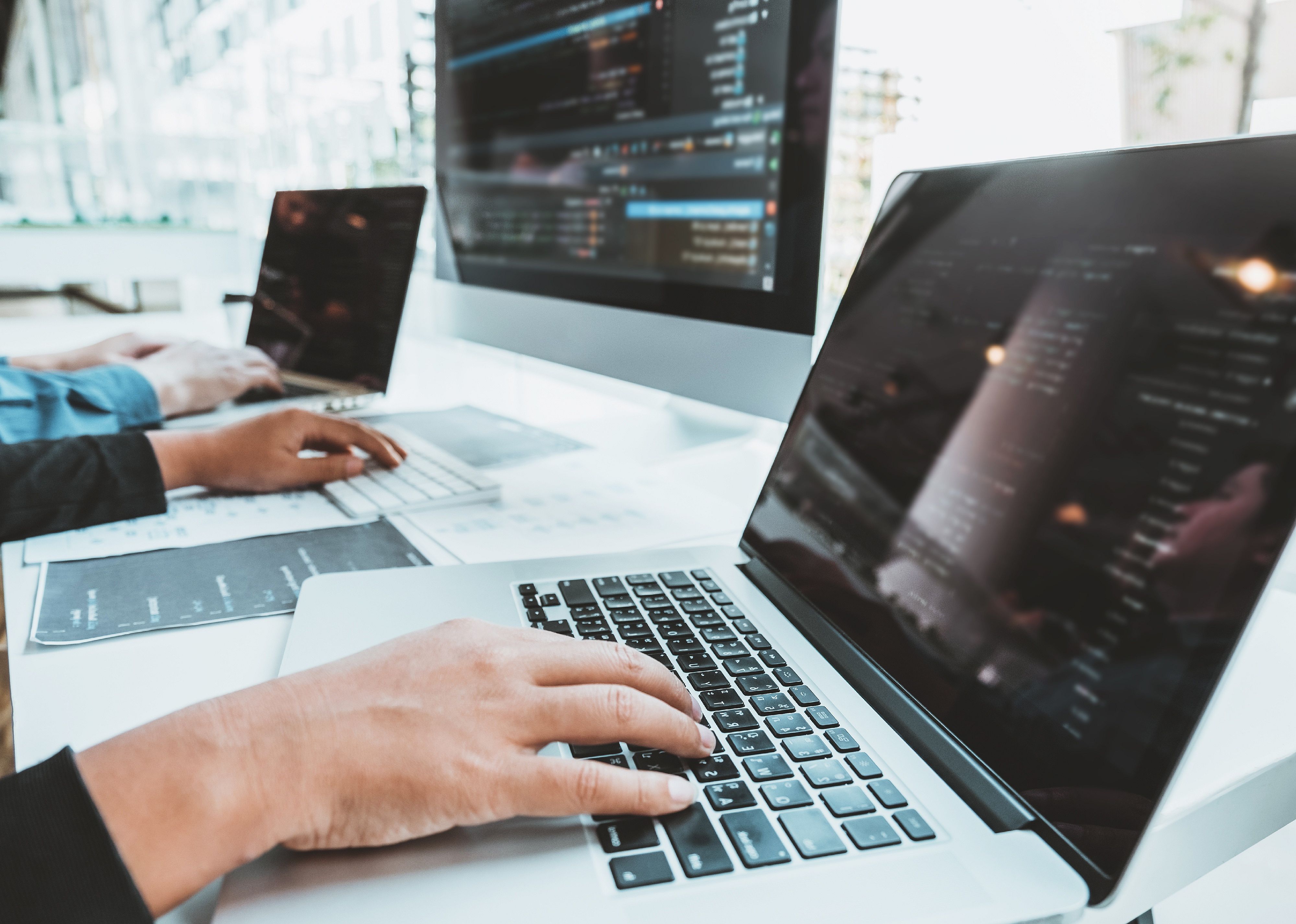 Computers and hands coding.