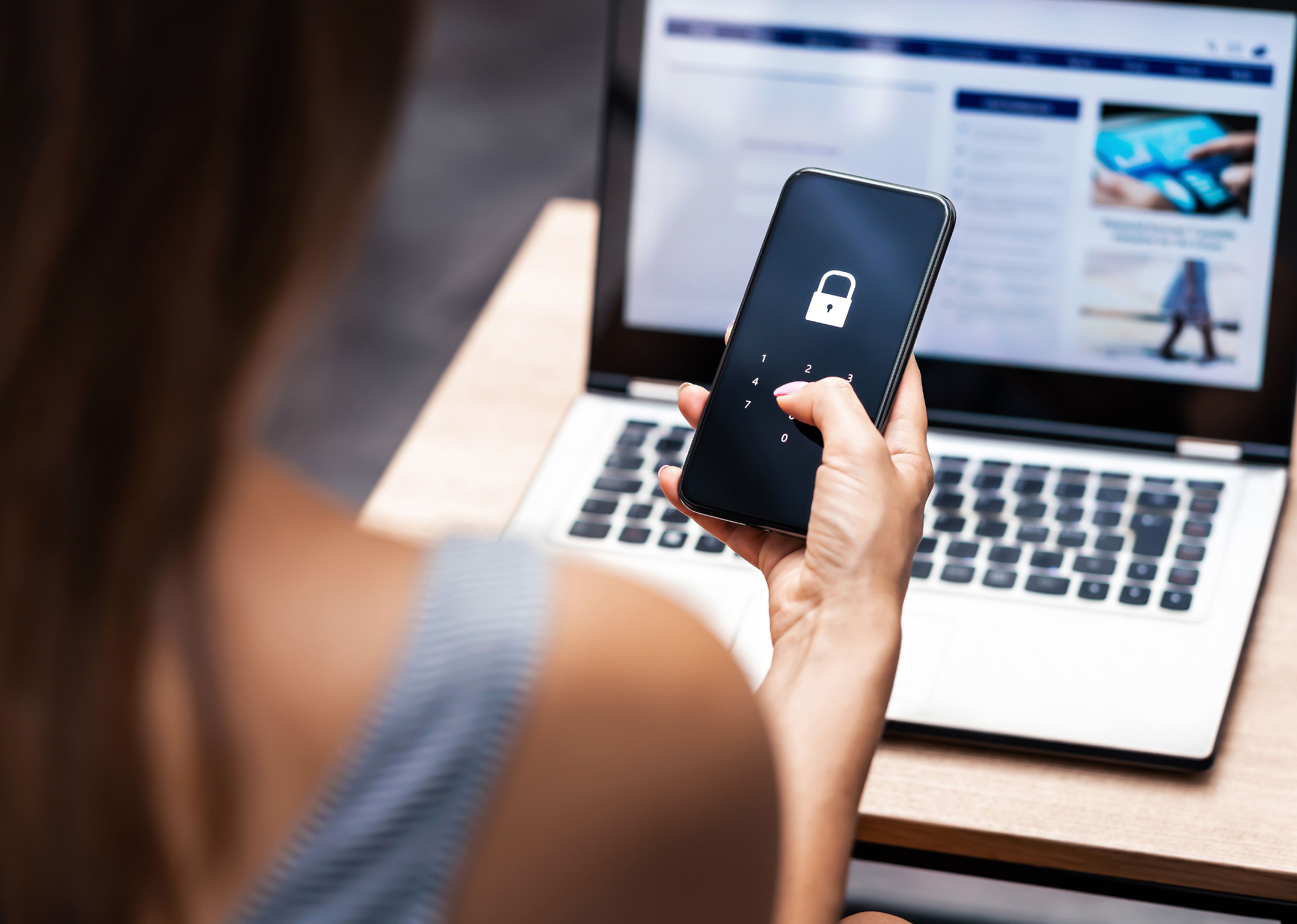 Woman holding smartphone with locked screen.
