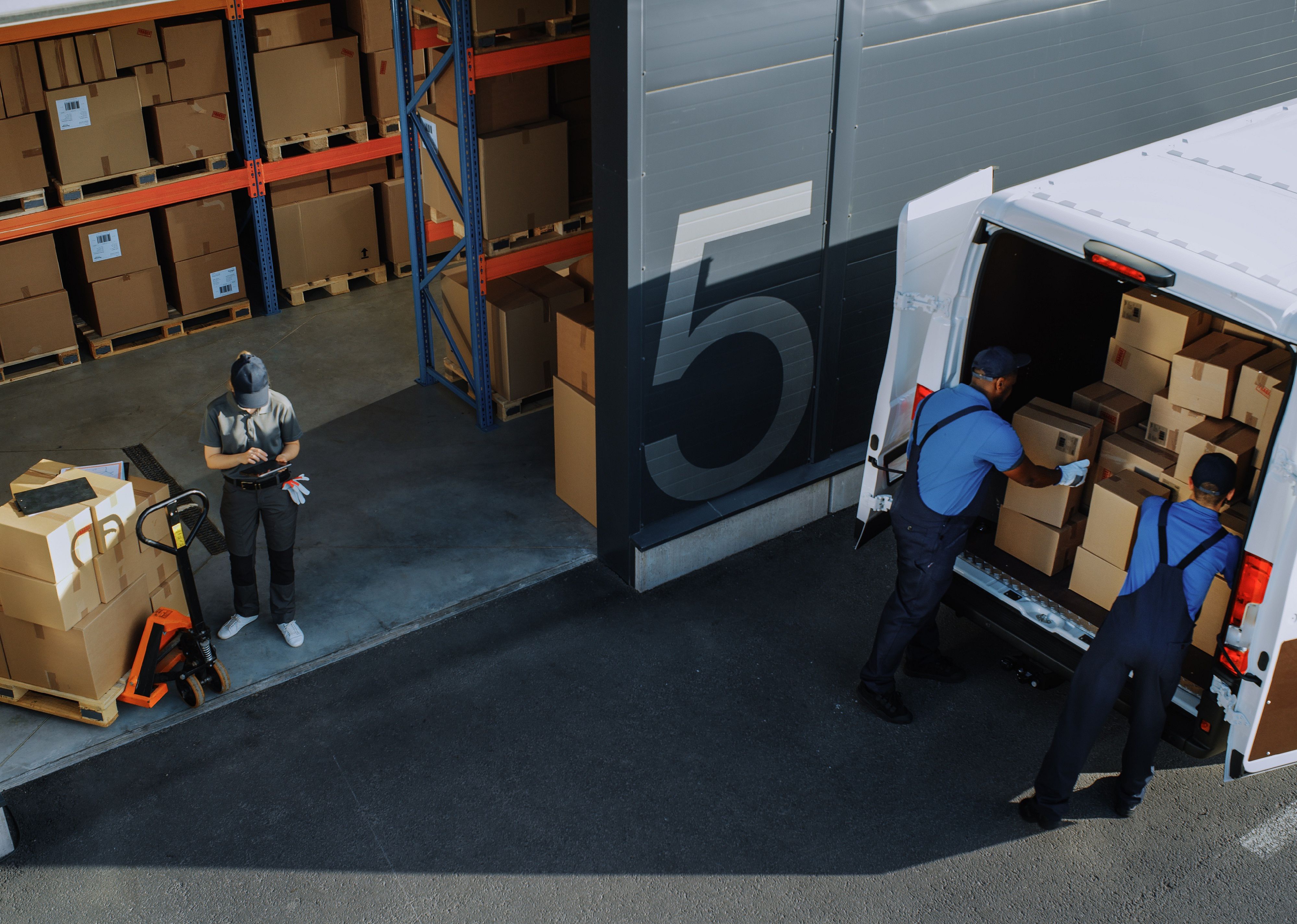 Packers load boxes into a van