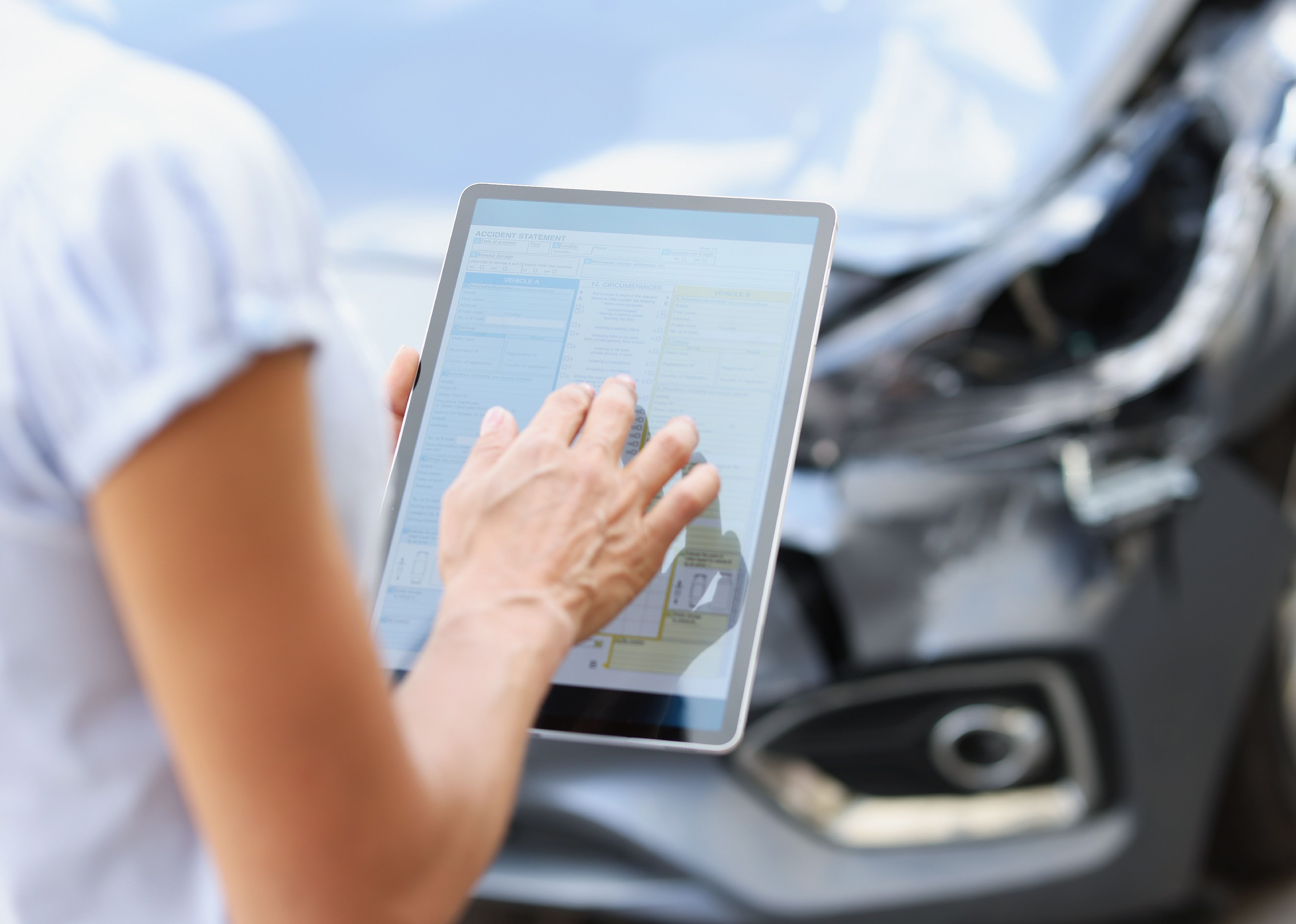Female agent filling out insurance claim on digital tablet 