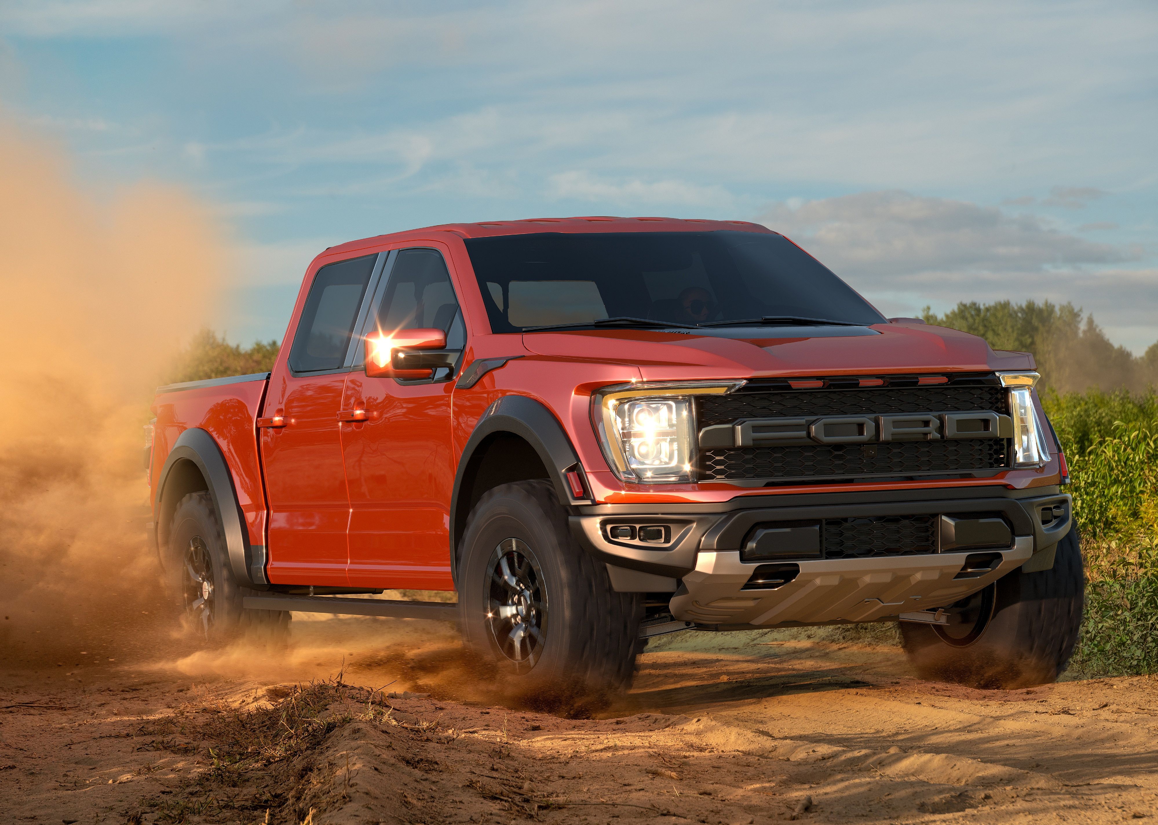 F-150 Raptor driving through dirt.