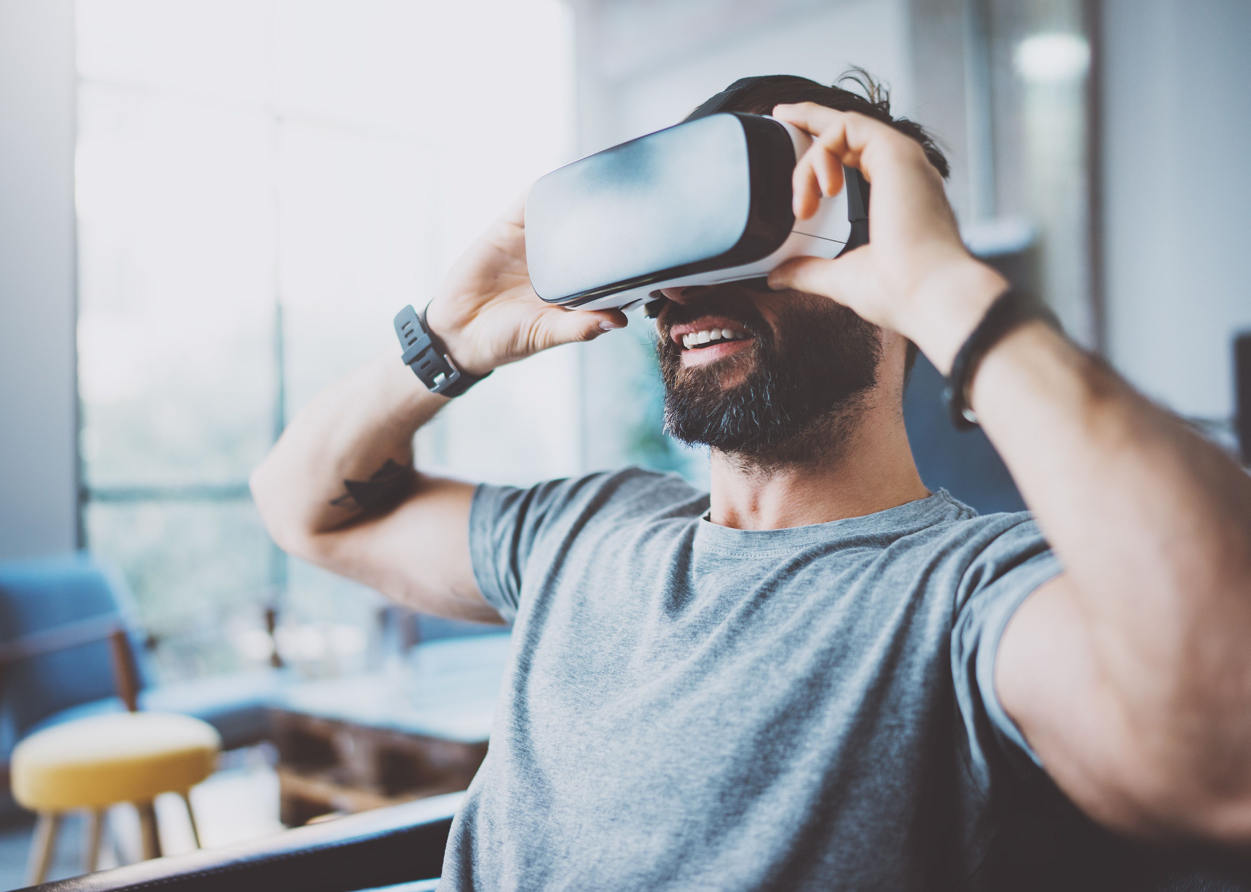Bearded man wearing virtual reality goggles.