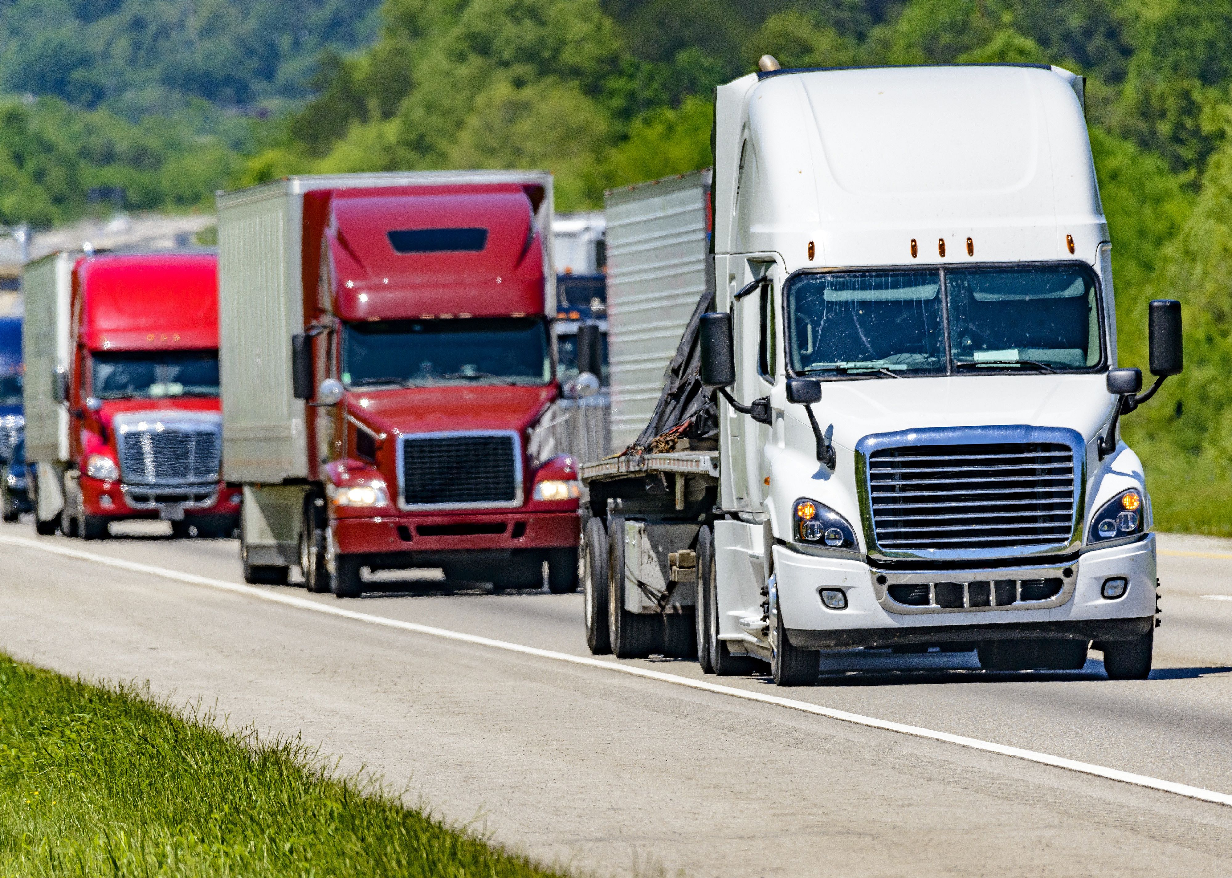 A line of eighteen-wheelers on an interstate highway.