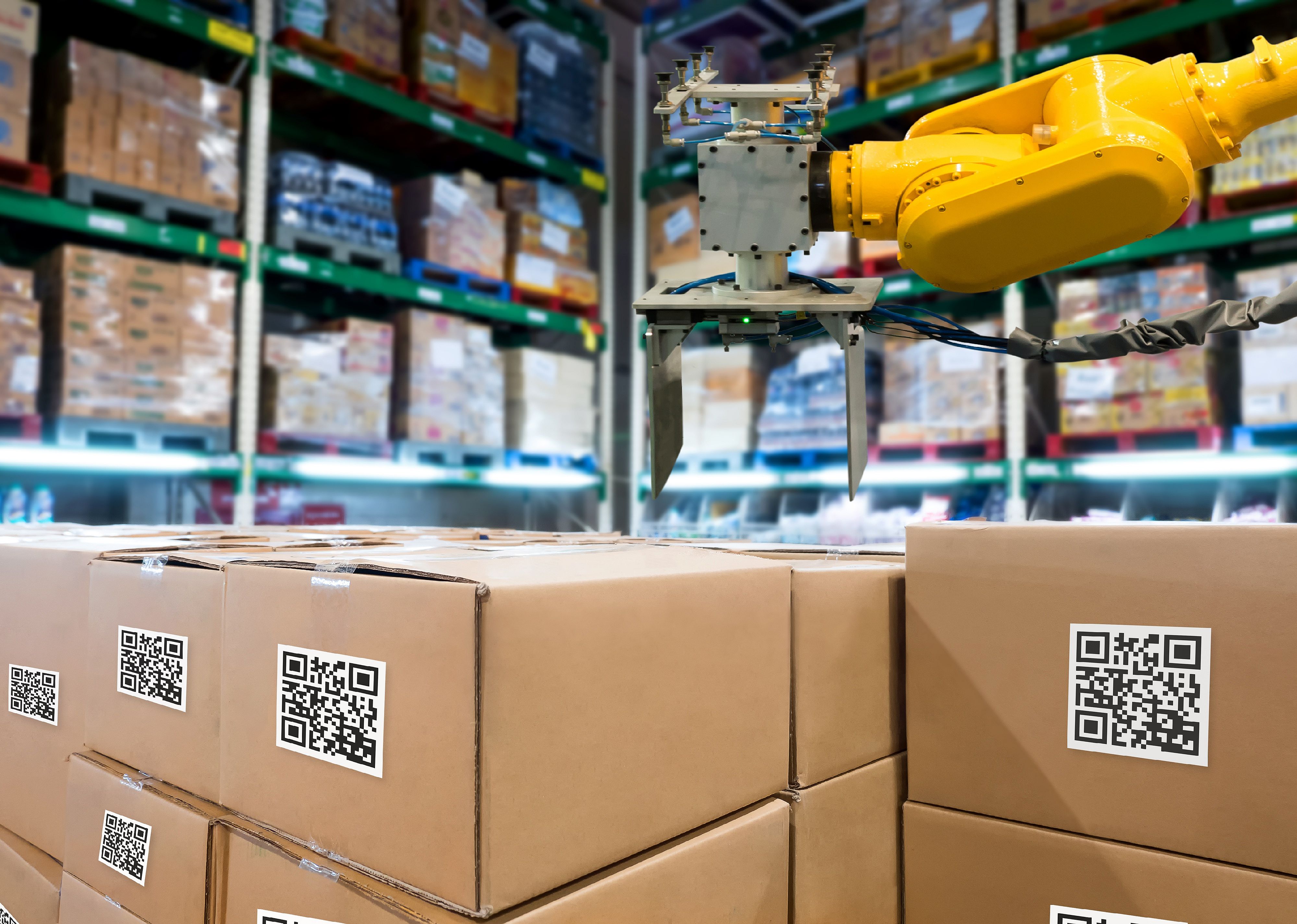 Group of boxes and Automation robot arm machine in storehouse.