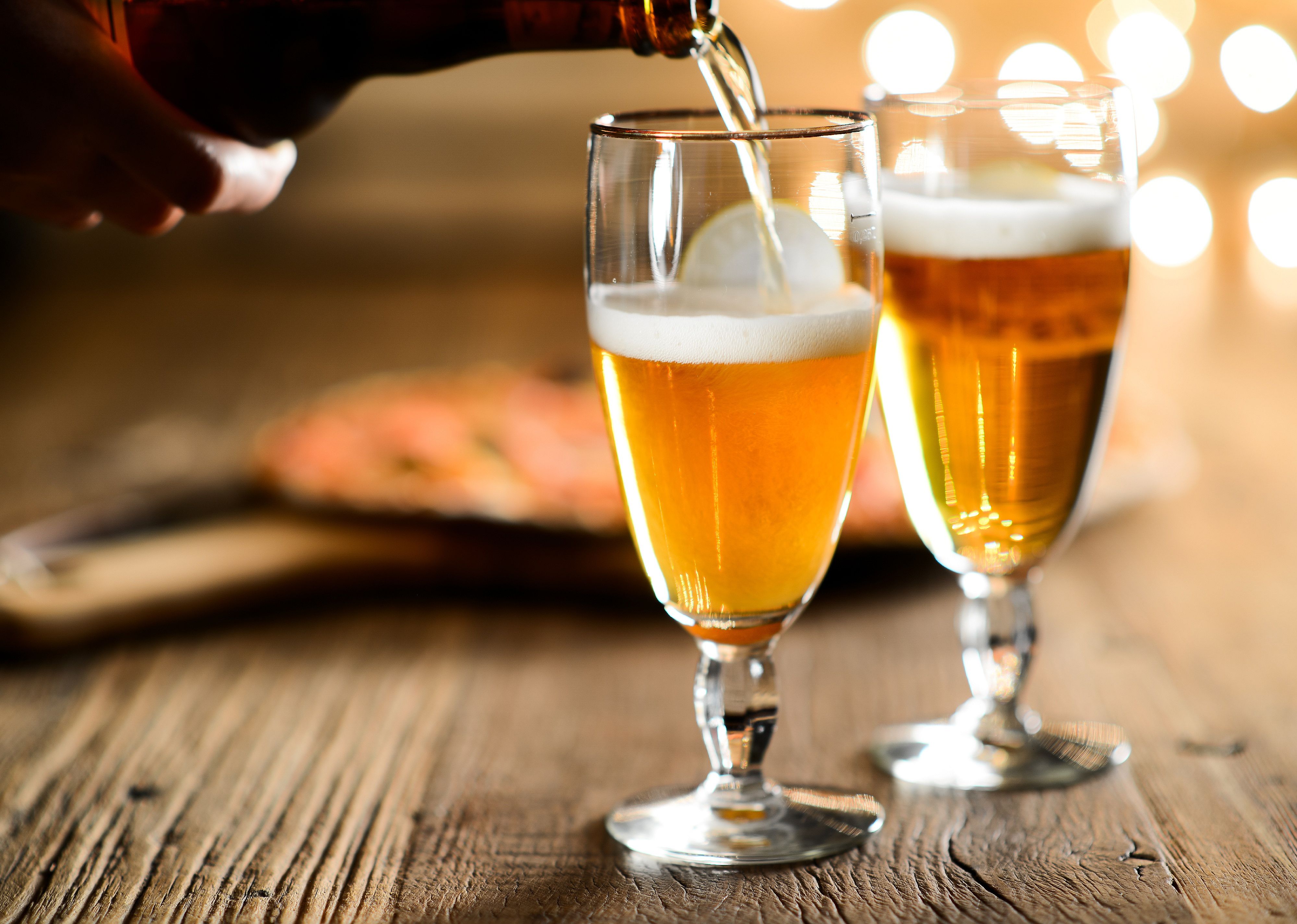 A hand pouring fresh beer in a glass