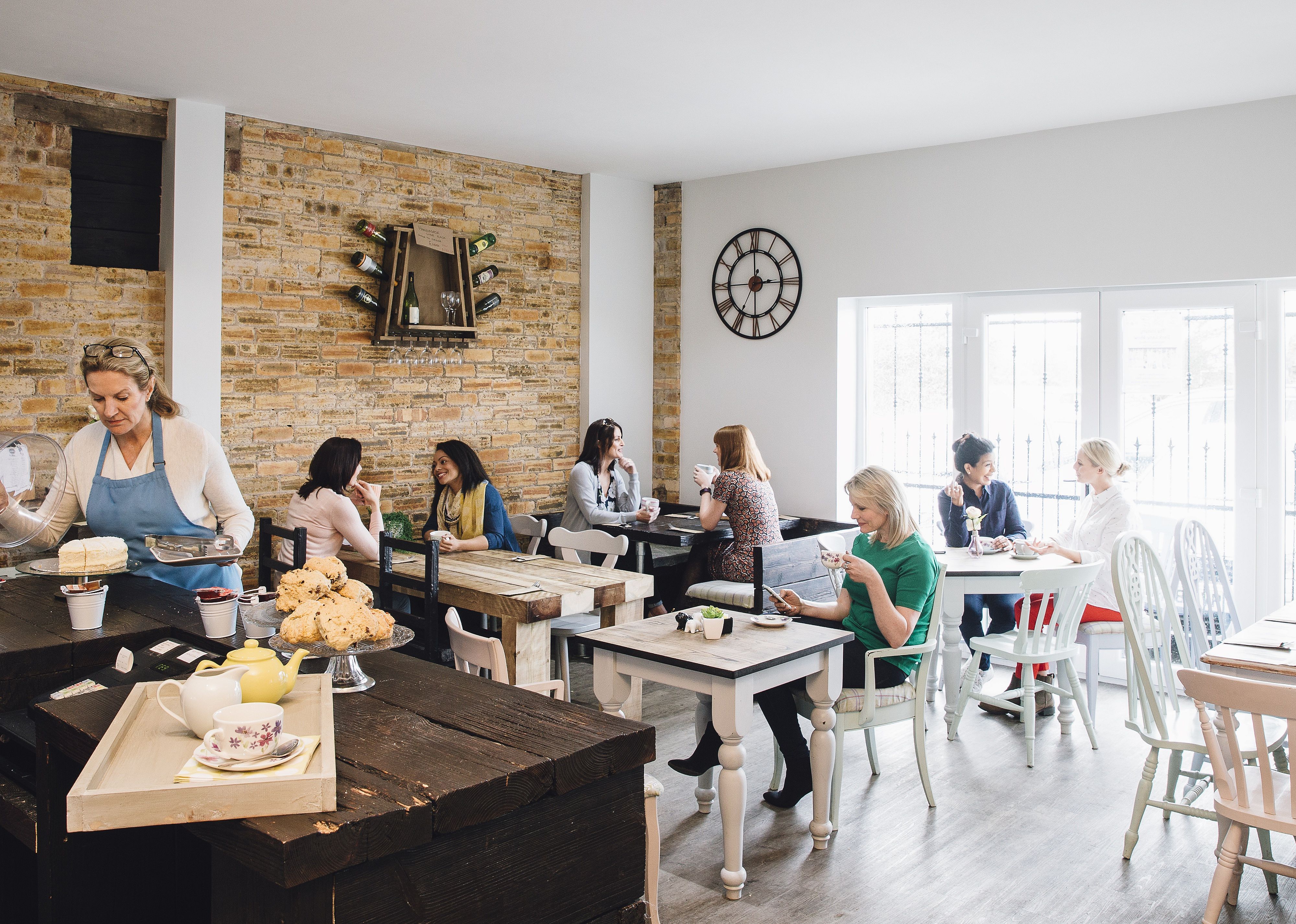 Room shot of a busy cafe full of women socialising.
