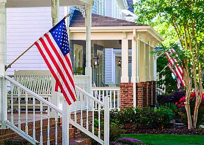 A line of suburban homes with American Flags.
