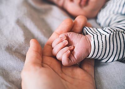 Baby's hand into parent hands.