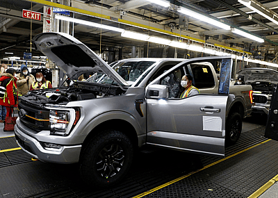 Workers assemble cars at a Ford assembly plant.