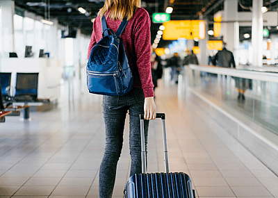 A woman reads the departures board at an airport