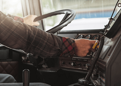 Trucker behind truck steering wheel.