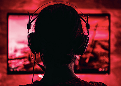 A woman wearing headphones and playing a video game.