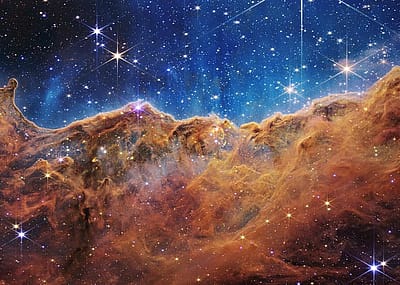 James Webb Space Telescope NIRCam Image of the 'Cosmic cliffs' in Carina Nebula via NASA.