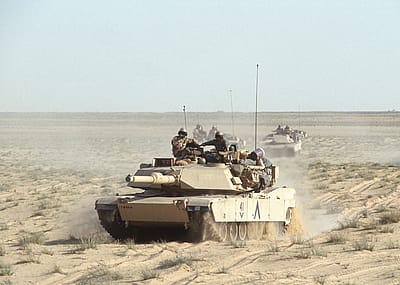 View of American M1A1 Abrams tanks as they cross the desert during the Gulf War, Iraq, 1991.