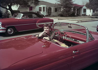 Actor and singer Debbie Reynolds sits in the driver's seat of a red convertible Ford Thunderbird, in Burbank, California, in March 1955.
