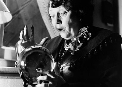 A fortune teller in London's Piccadilly is surprised at what she sees in a crystal ball, circa 1953.