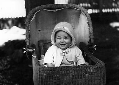 Happy baby in a buggy in the late 1930s.