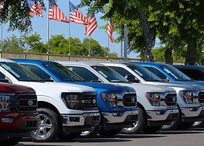 A row of Ford F-150 trucks for sale at a car dealership