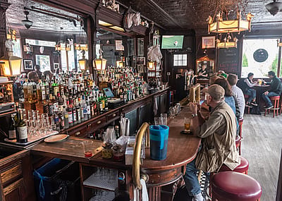 Patrons sitting at bar counter at the White Horse Tavern in New York City.