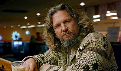 Jeff Bridges as The Big Lebowski sitting in the bowling alley