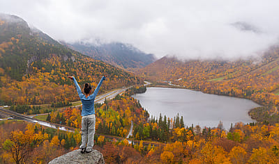 Woman posing in front of beautiful Echo Lake from Artists Bluff Loop in New Hampshire.