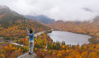 Woman posing in front of beautiful Echo Lake from Artists Bluff Loop in New Hampshire.