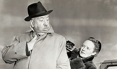 Alfred Hitchcock poses for a "sinister" type snapshot for his wife Alma Reville