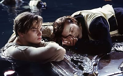 Leonardo DiCaprio and Kate Winslet in the final act of the film 'Titanic,' with Jack in the water as Rose rests on a floating piece of wood paneling.