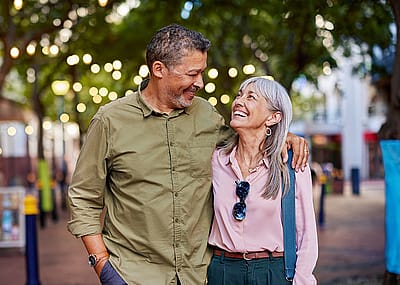 Cheerful couple walking on pedestrian street.