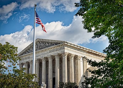 A photo of the Supreme Court building with a blue sky in the background.