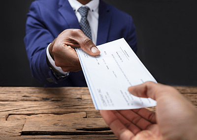 A business person handing a check to an employee