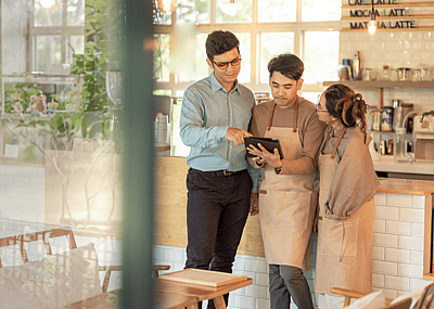 Small business owners talking around an iPad.