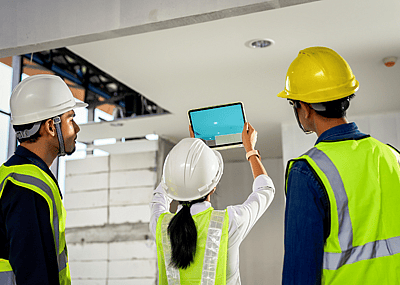 A construction engineering team using technology software through tablets to scan building construction