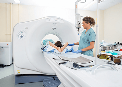 A nurse preparing a patient for a CT scan in a hospital room