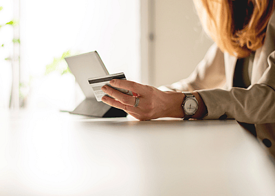 A woman typing in her credit card details while online shopping