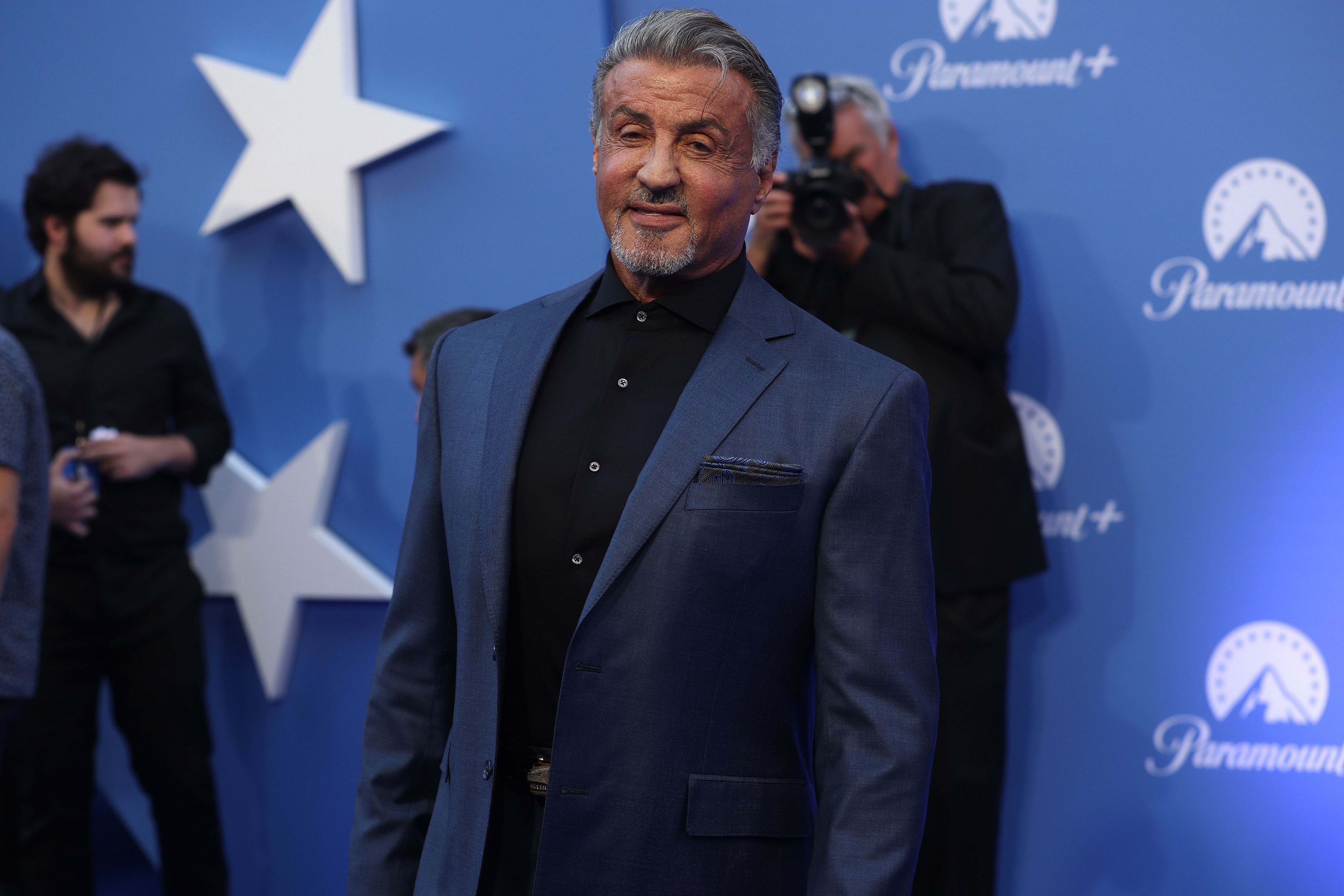 Sylvester Stallone in a dark blue suit.