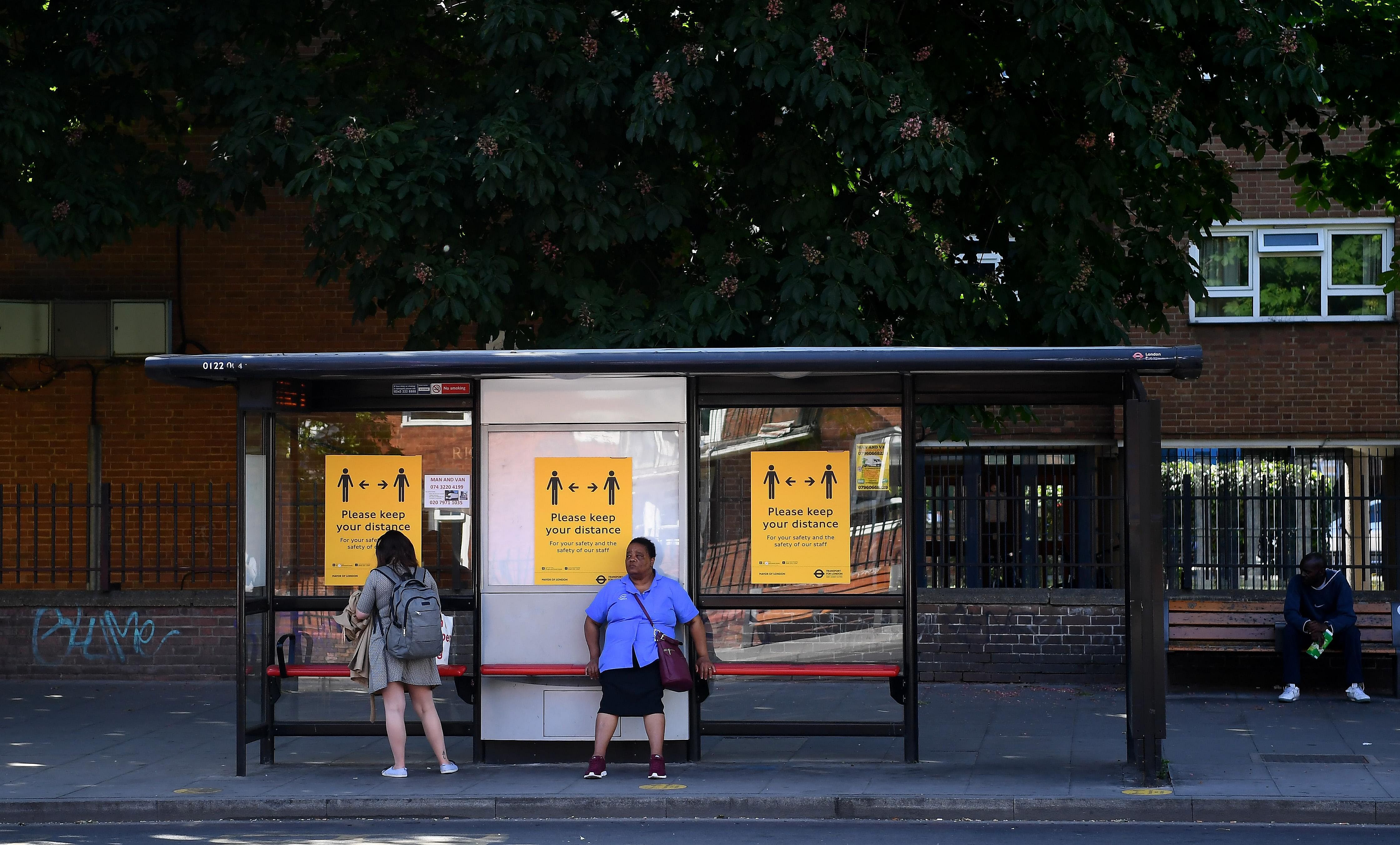Signs to remind of distancing at a bus stop in London