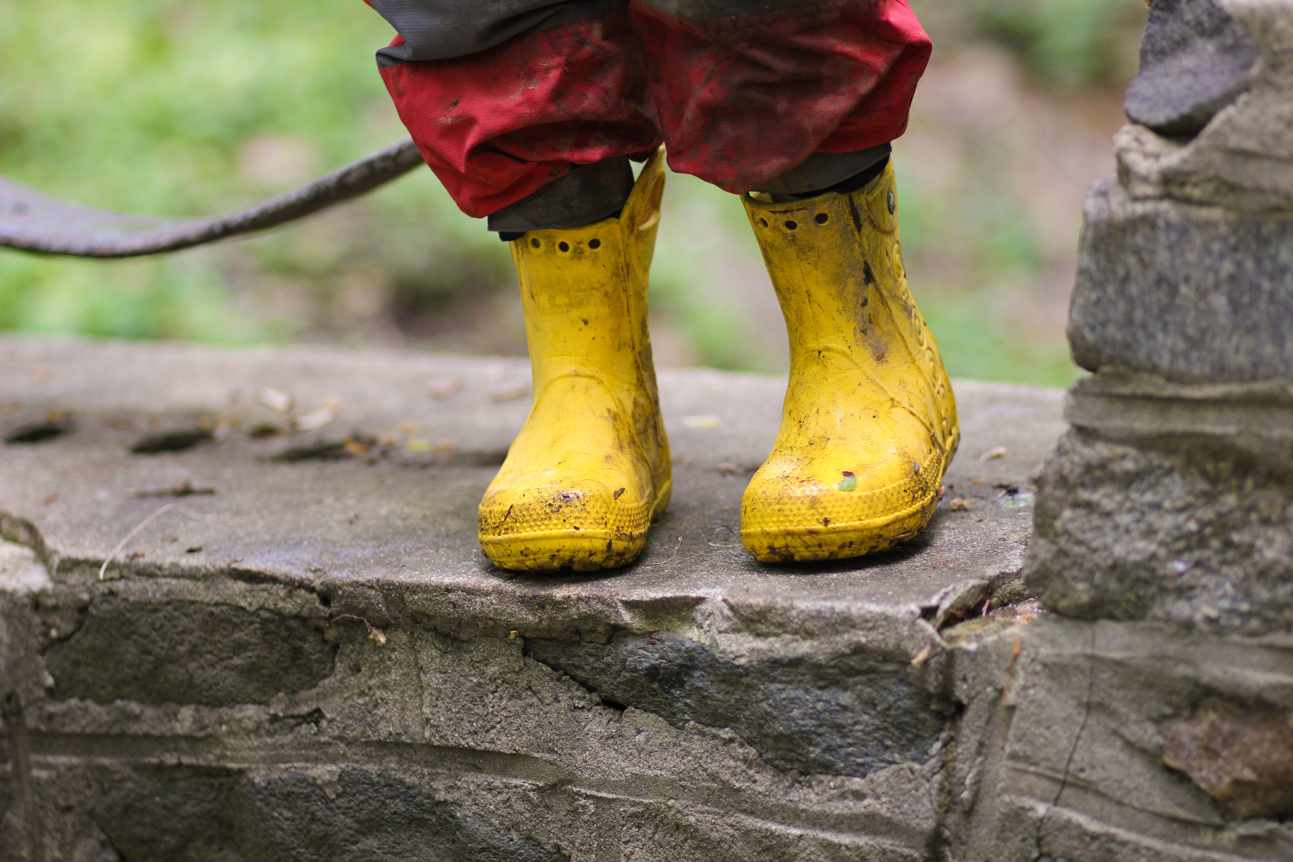 A child's feet in yellow rain boots.