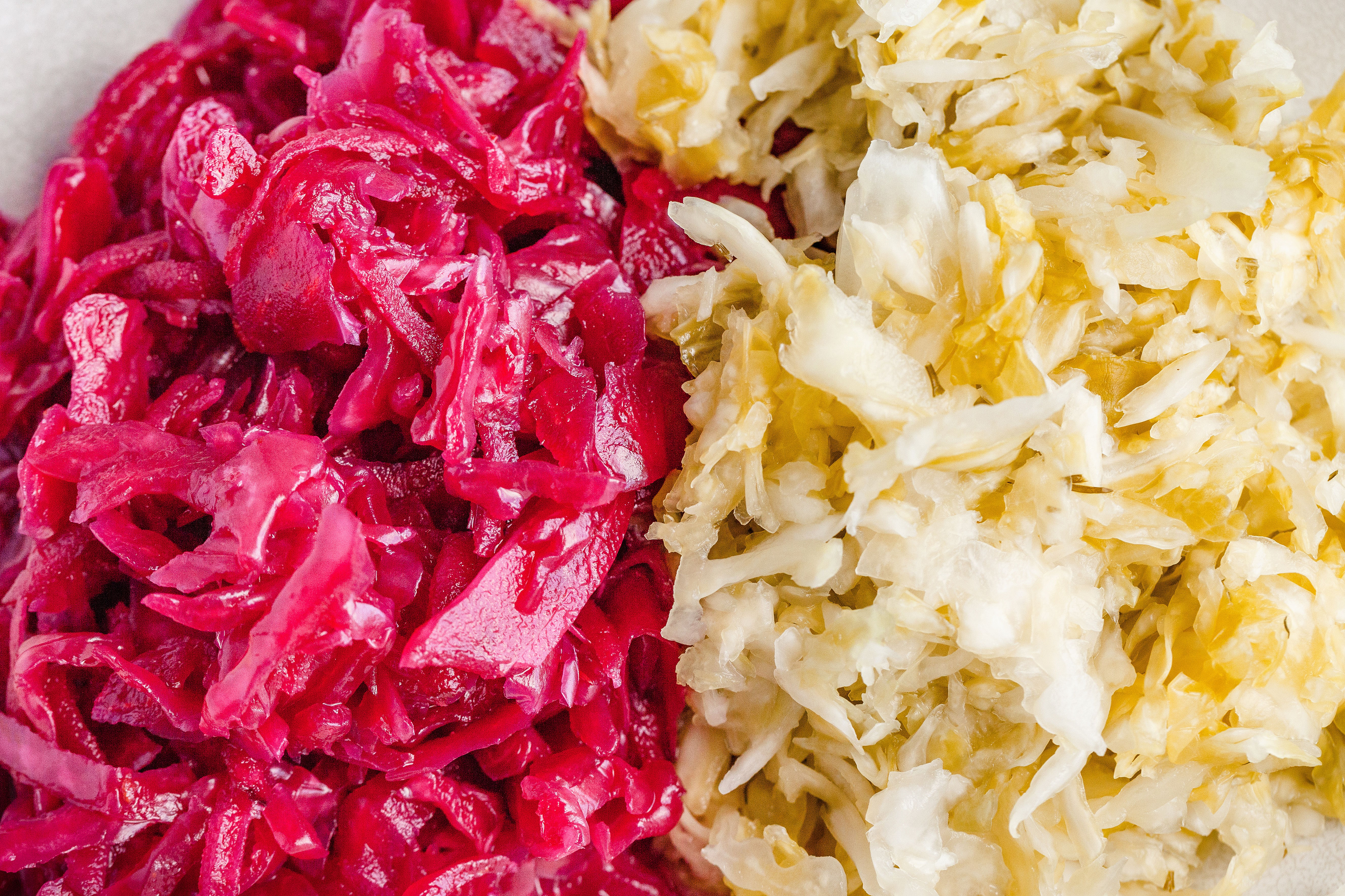 Side by side view of red and white sauerkraut.