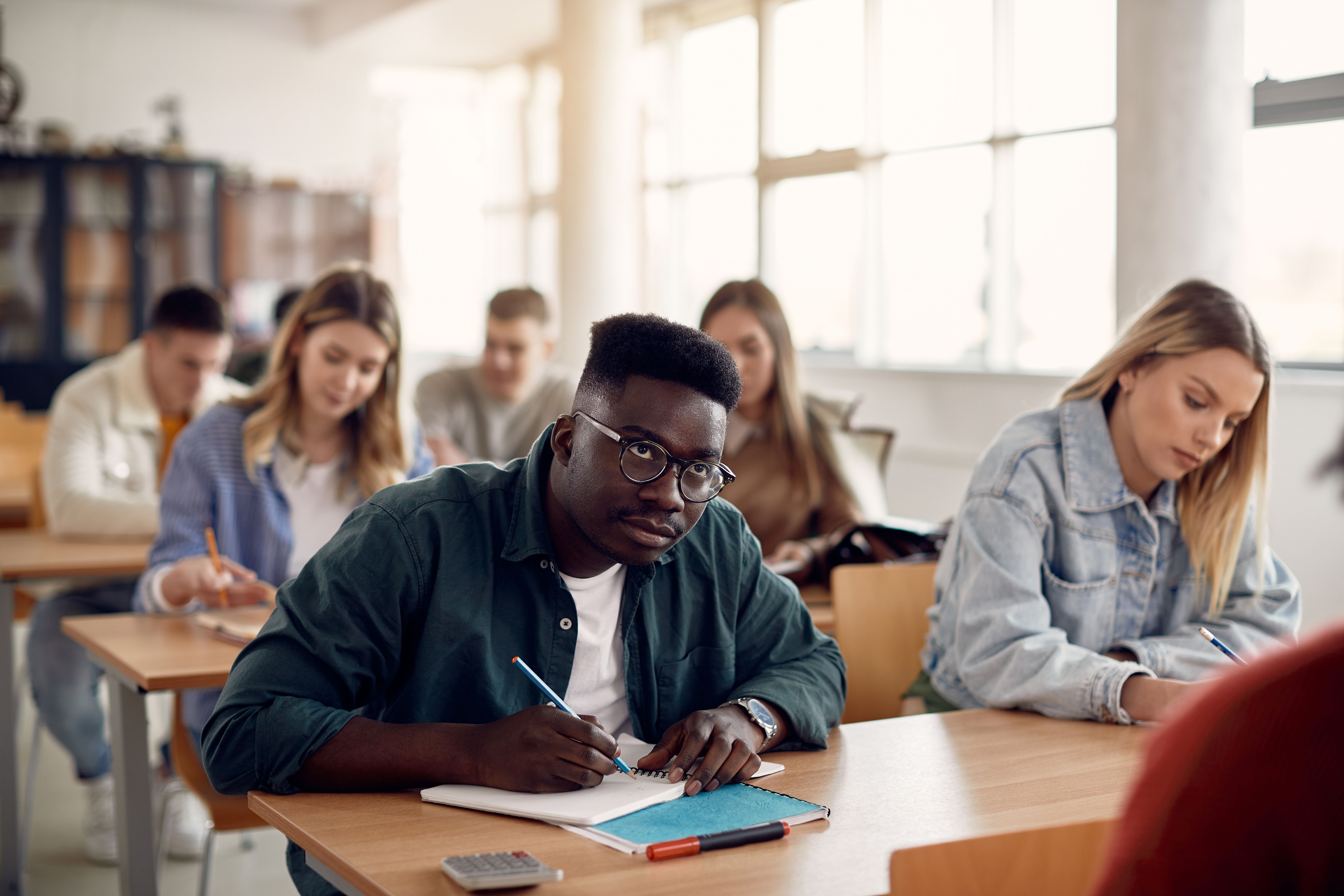 Student taking notes during lecture in the classroom