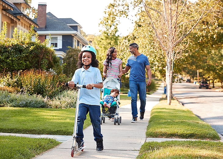 Family walking on suburban street.