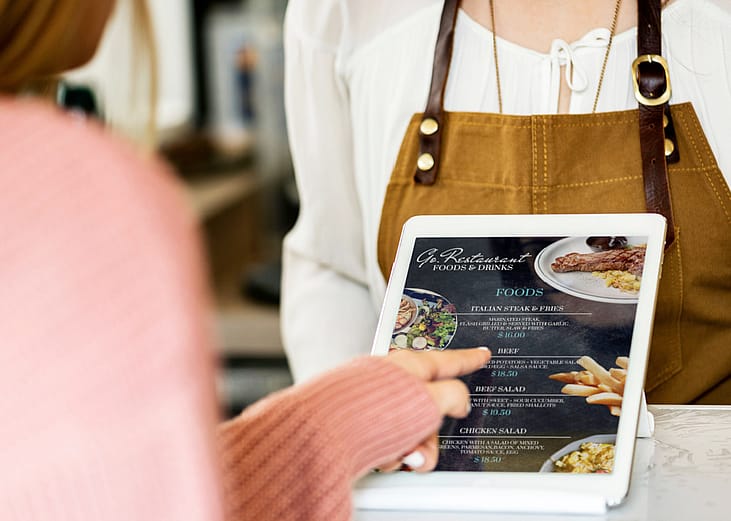 Customer placing a food order with tablet at a restaurant. 
