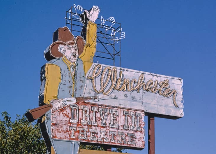 Winchester Drive-In neon cowboy sign during daytime.