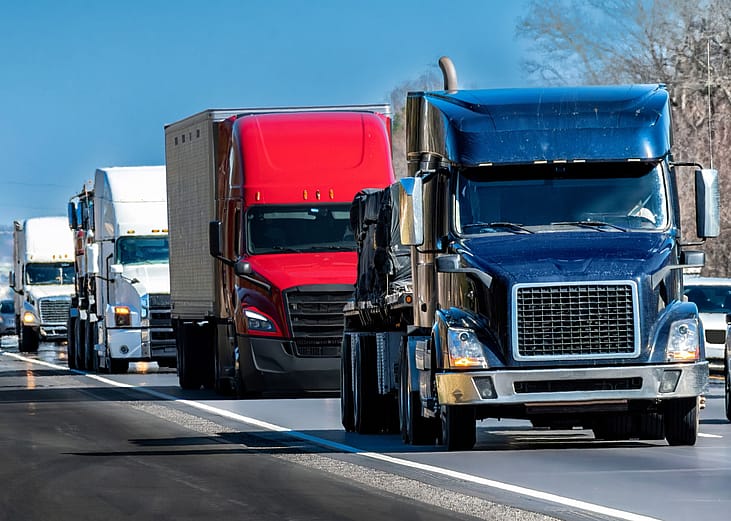 Row of trucks driving on highway