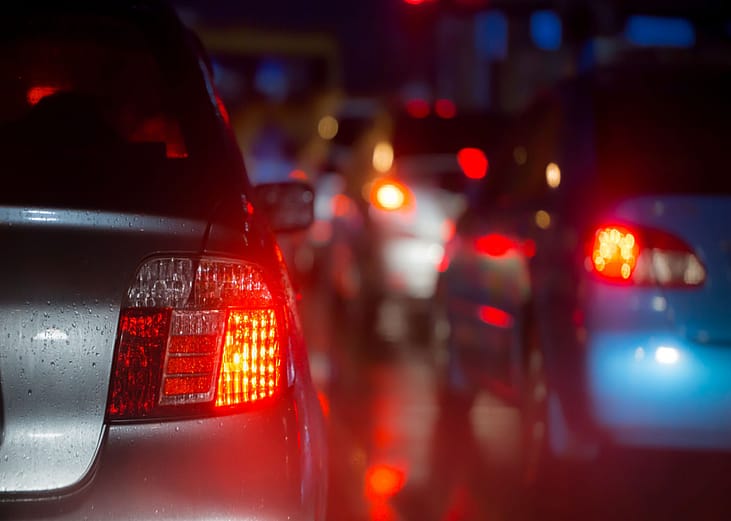 Red car brake lights on busy road at night  