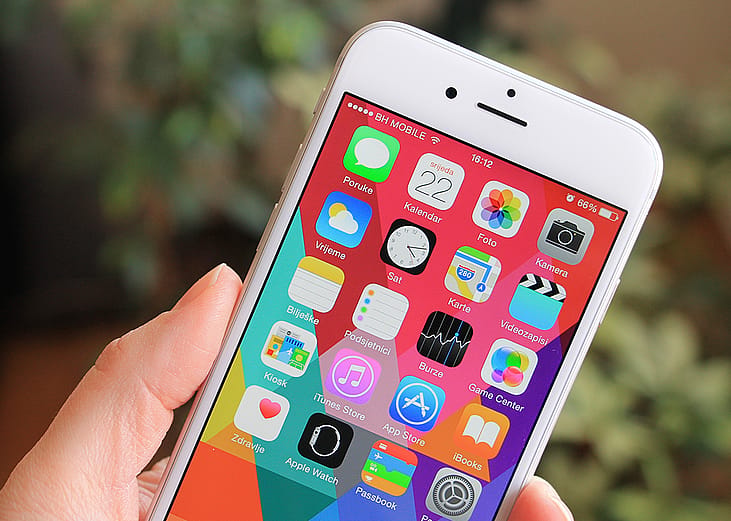 iPhone 6 with colorful screen in person’s hand.