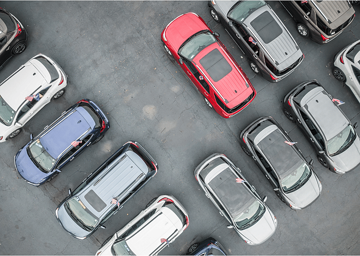 Aerial view of used cars in a dealership lot.