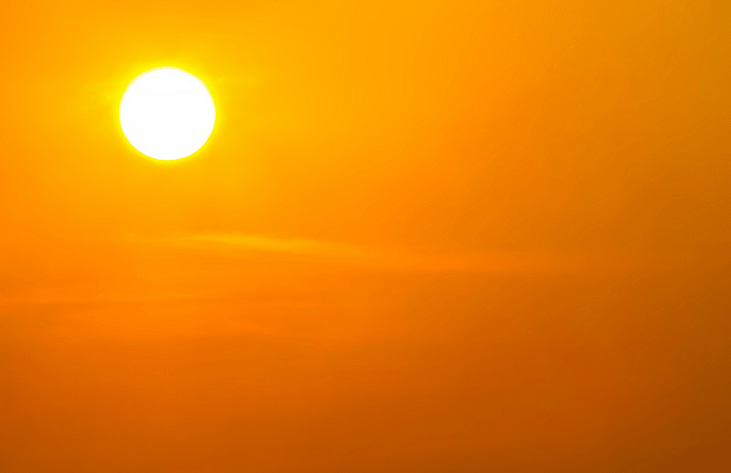 The sun shining bright on a hot day.